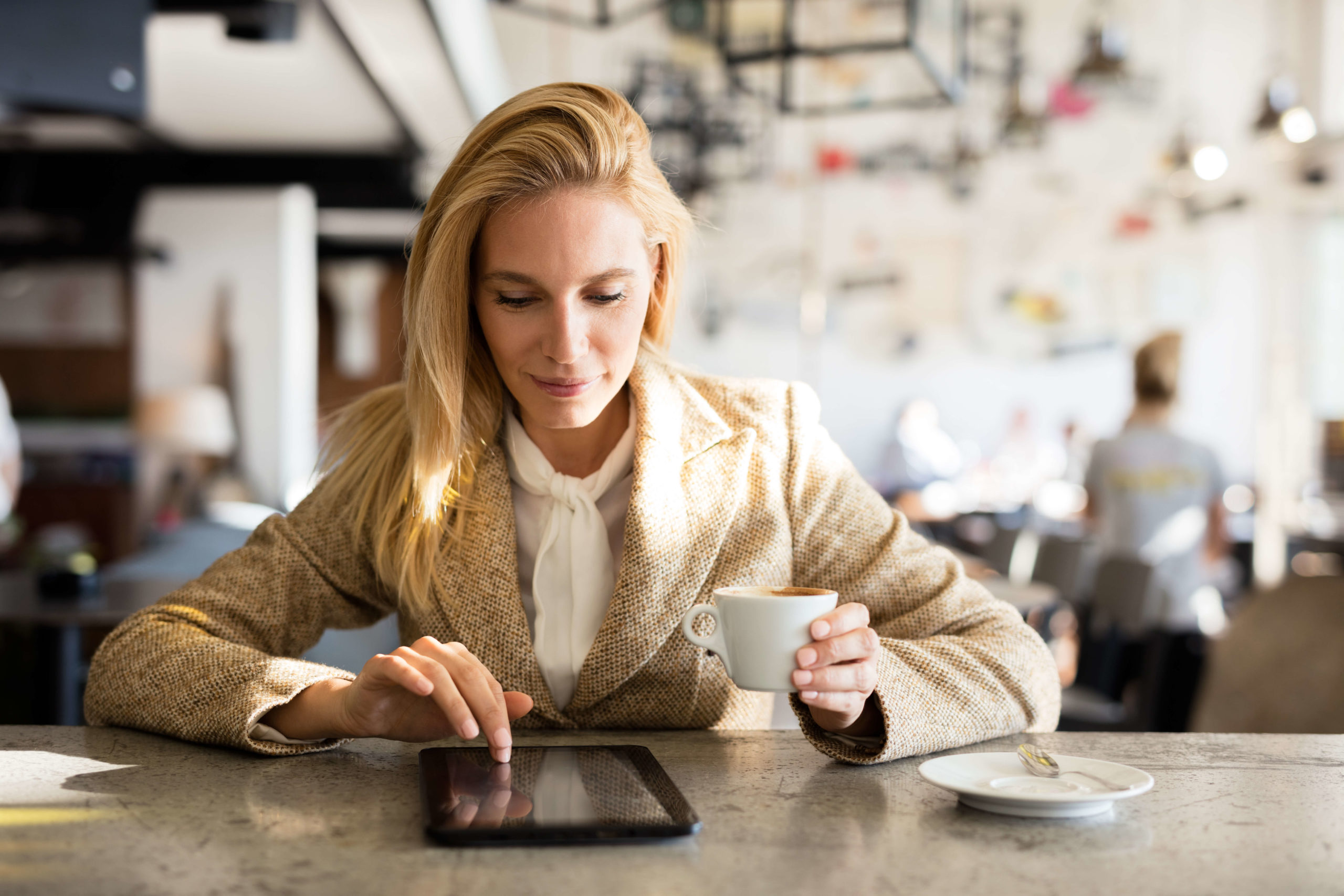 mladá bizniss dáma v mestskej kaviarni pije kávu a surfuje na webe_shutterstock_517295545